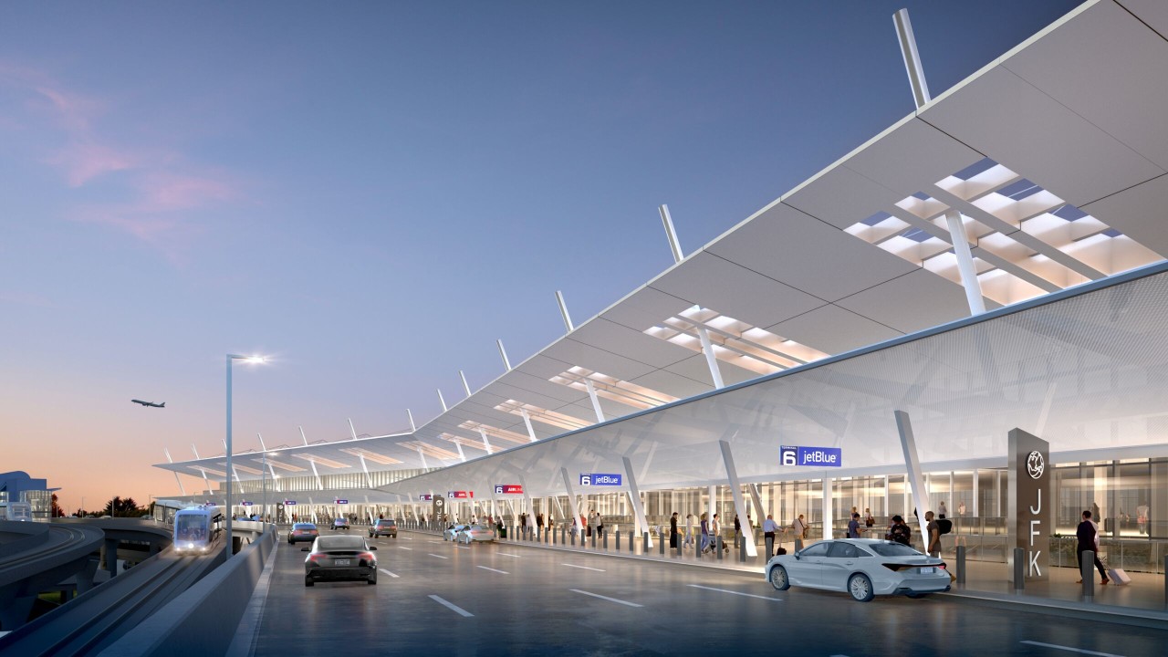 A modern airport terminal with a sleek design, featuring jetBlue signage and a clear evening sky. Vehicles and passengers are present in the foreground.